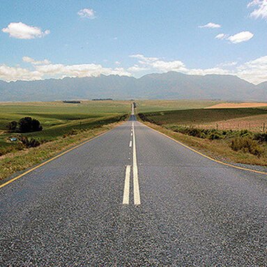 Straight road with mountains in background.