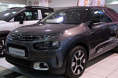 Front side view of a grey Citroen C4 Cactus in a showroom.