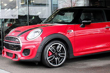 Side front view of a red Mini Cooper.