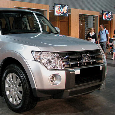 Front side view of a grey Mitsubishi Montero on showroom display.