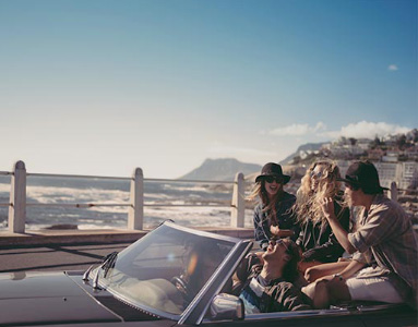 Group of friends parked in a convertible car with the sea next to them | Product offering | Hippo.co.za travel partner driving 