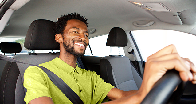 Smiling driver behind the wheel, protected by car insurance