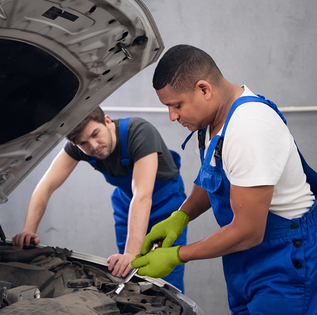 two mechanics working on a car