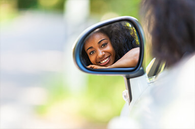 Woman looking in the rear-view mirror