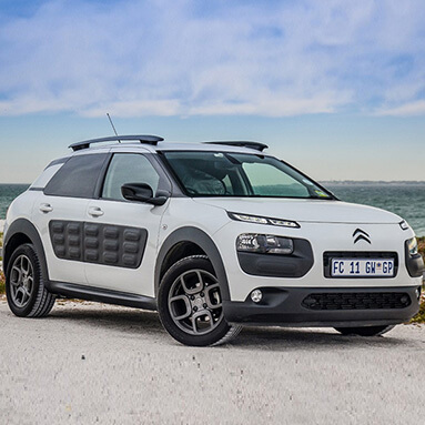 Side view of white Citroën Cactus on the beach with ocean view background