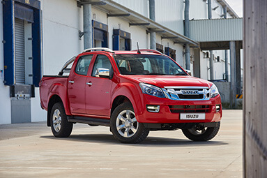 Red isuzu bakkie parked sideways in parking lot with concrete grey background