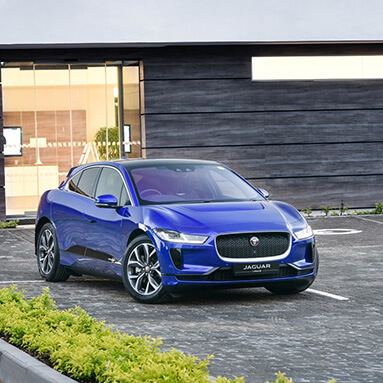 Blu Jaguar parked outside a building