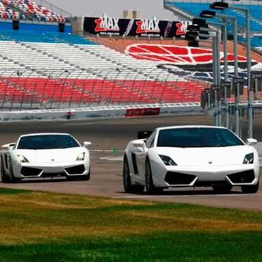 Two white lamborghini’s driving on race track