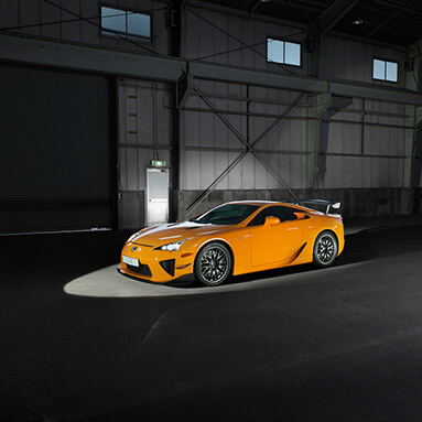 Front side view of a yellow Lexus LFA in a warehouse.