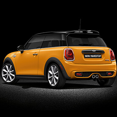 Yellow and black 3-door Mini Cooper S Hatchback against black backdrop.