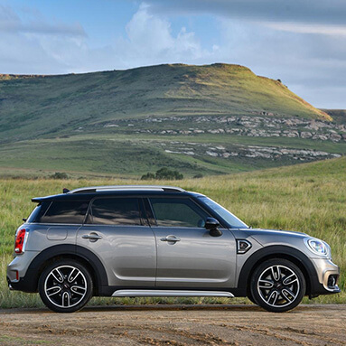 Side view of the MINI Countryman S with mountainous background.