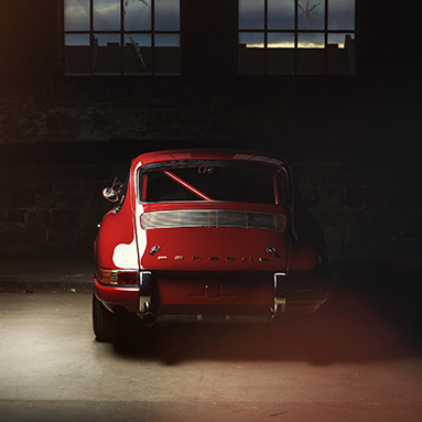 Classic red Porsche sports car parked in dimly lit garage