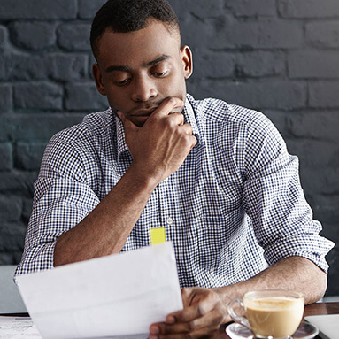 Man holding chin and contract while in contemplation.