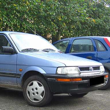 Front side view of a blue Subaru Impreza.