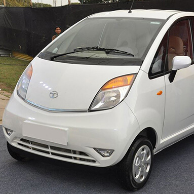 Front side view of a white Tata Nano.