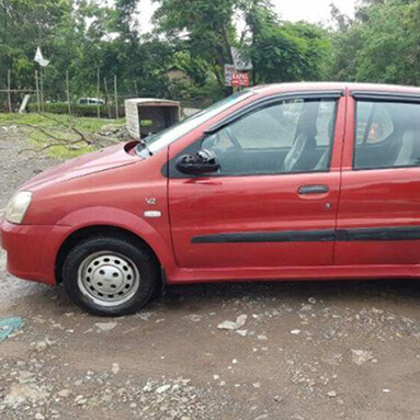 Side view of a red Tata Indica.