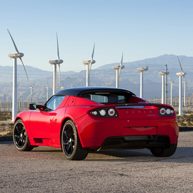 Back side view of a red and black Tesla Roadster 2.5S.