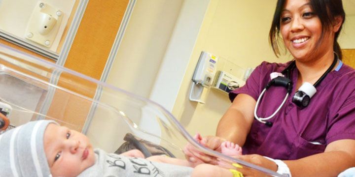 Nurse holding baby’s feet.