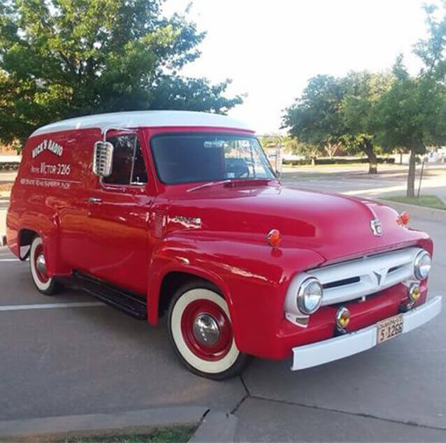 Front side view of a Red 1953 Panel Truck.