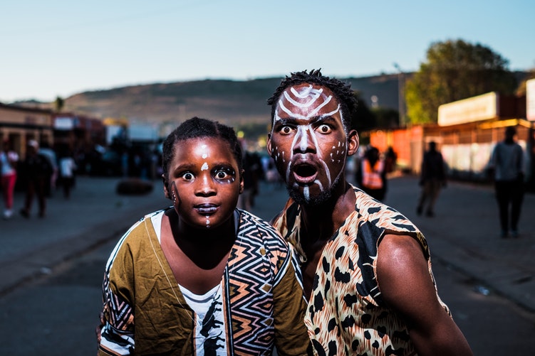 Two face-painted expressionists in the streets of Mamelodi