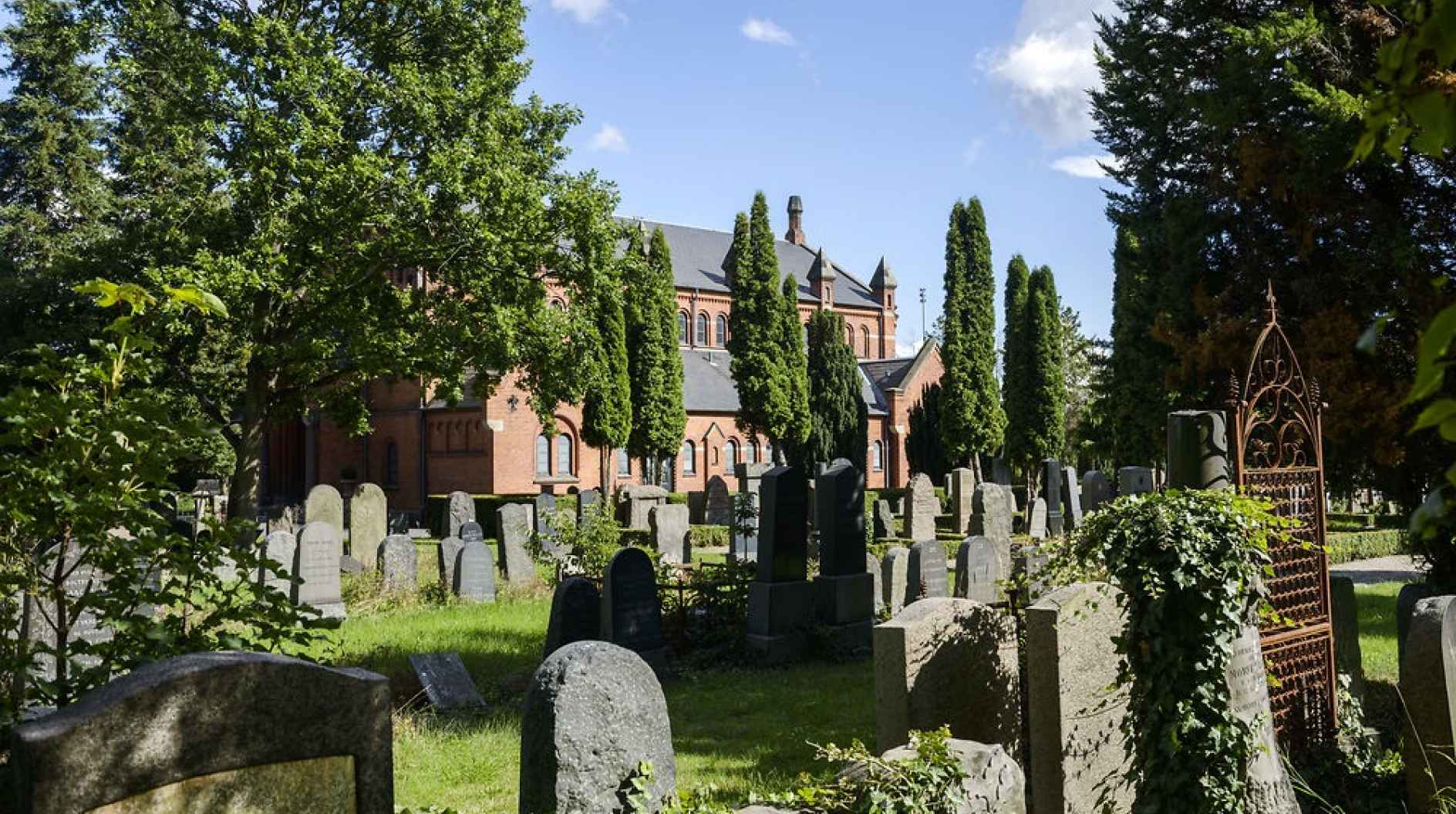 Graves in a cemetery in front of a cathedral. 