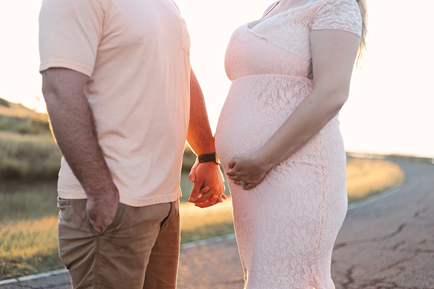 Pregnant couple holding hands