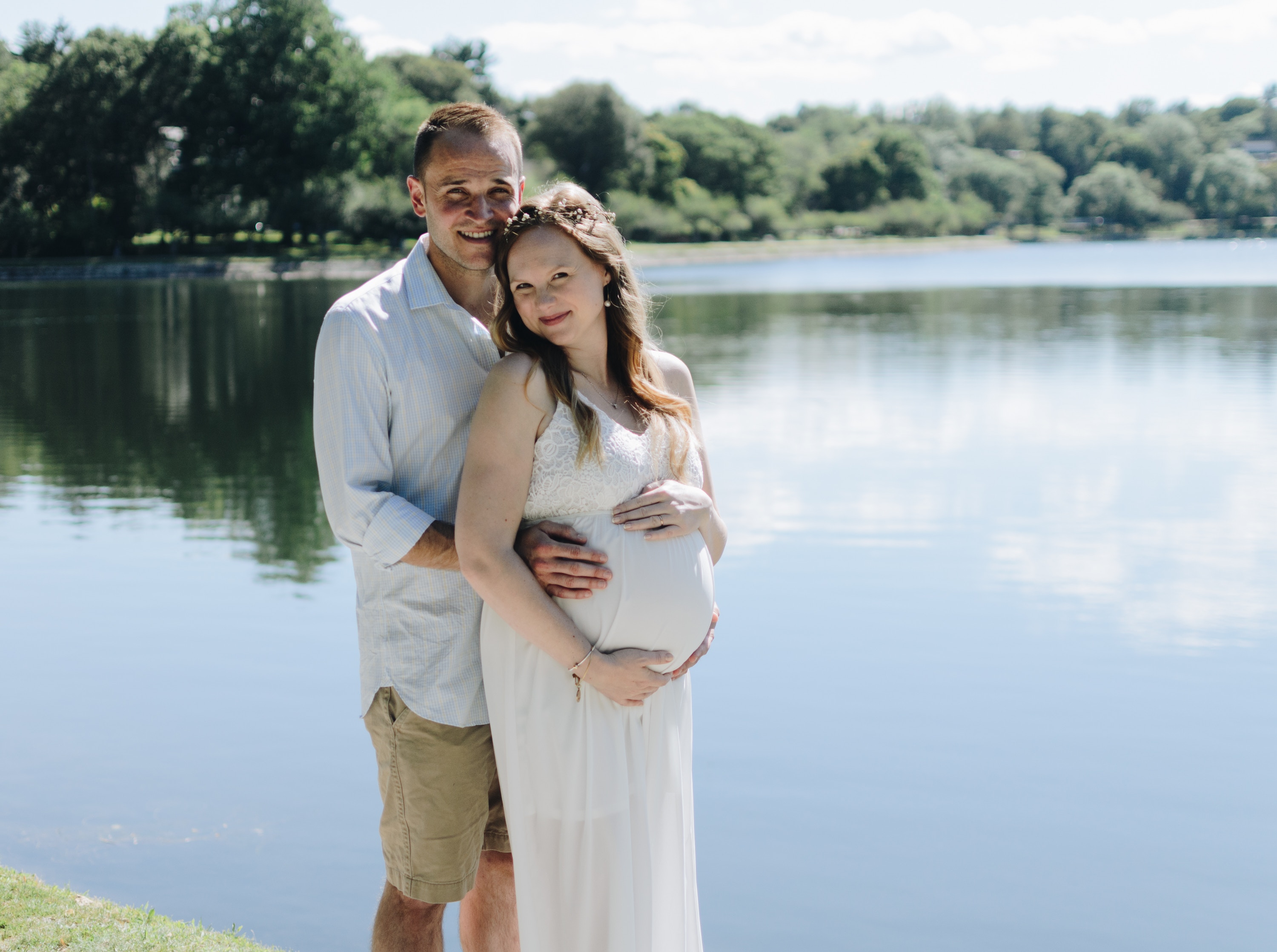 Pregnant couple by a riverbank