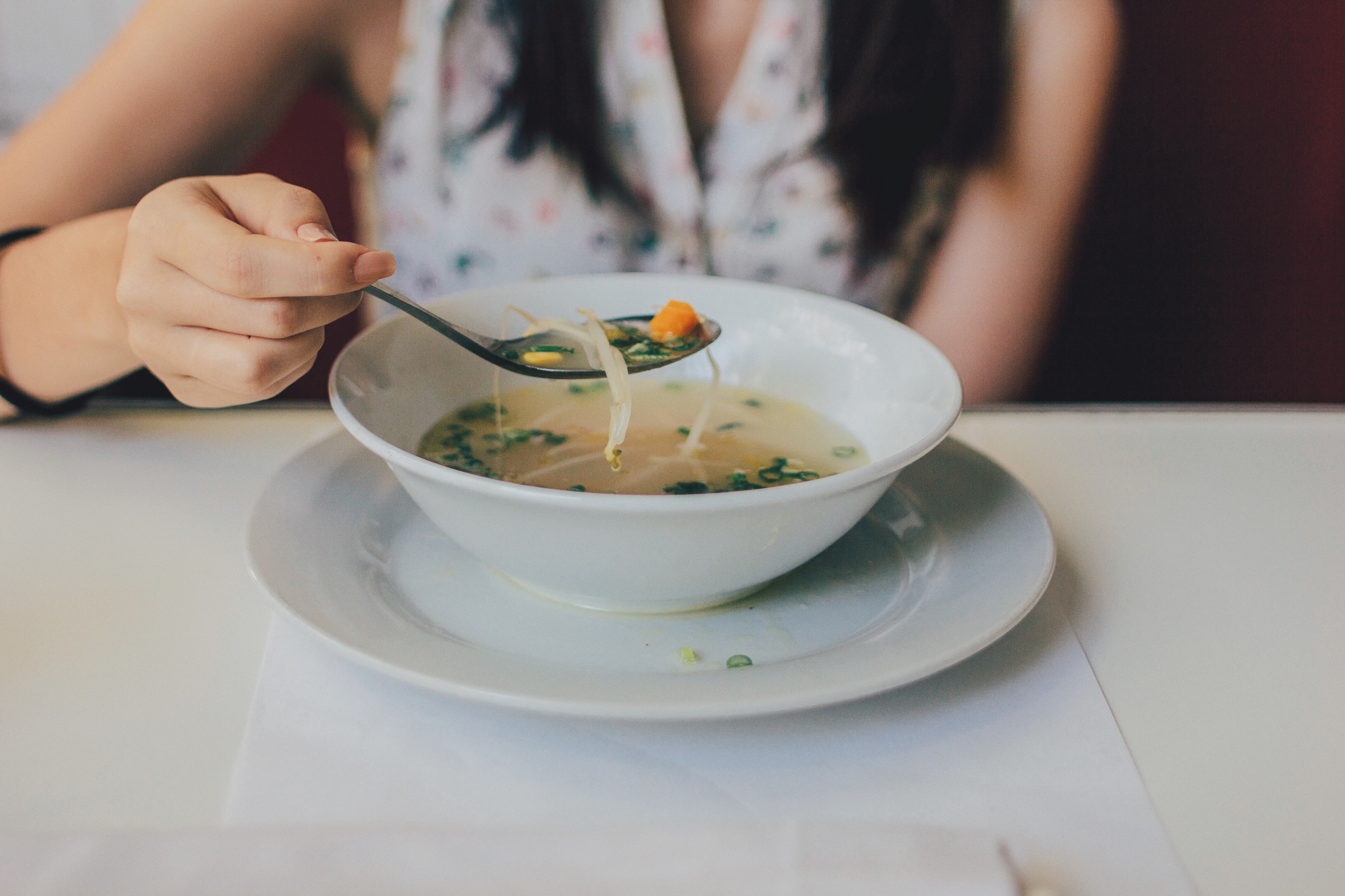 Spooning soup from a bowl