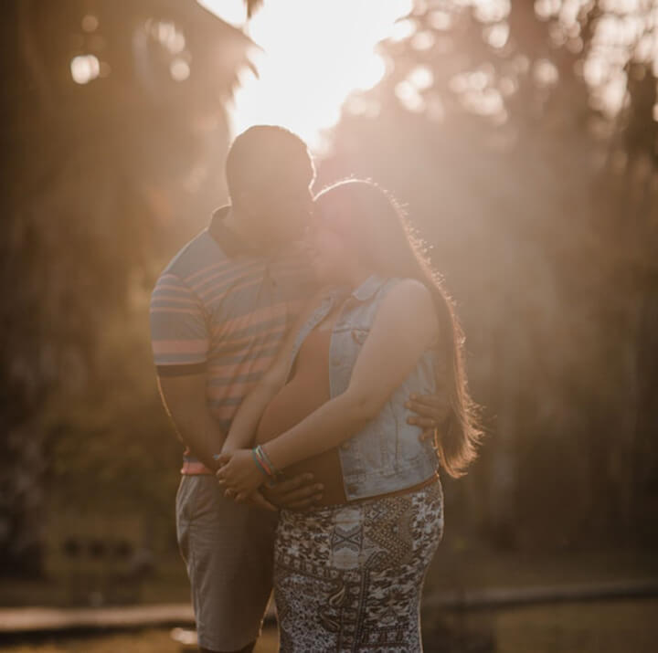 Loving, pregnant couple at dusk.