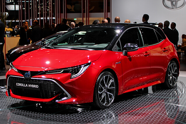 Front side view of a red 2018 Toyota Corolla Hybrid.