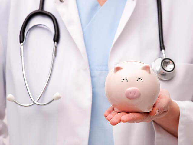 Doctor with stethoscope around neck holding piggy bank in left hand