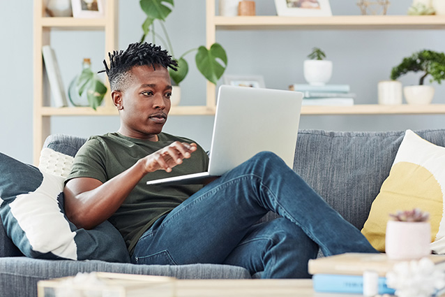 Man sitting on his laptop comparing different life insurance quotes for the best deal