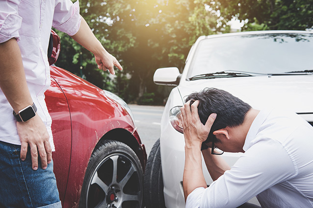 Two men talking after a car accident and are covered by third party liability insurance - Man upset because he was in an accident without third-party liability insurance