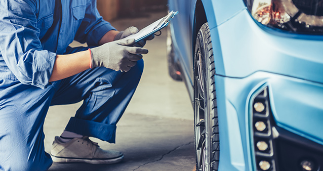 Mechanic checking customer claim order for insurance issues before fixing car