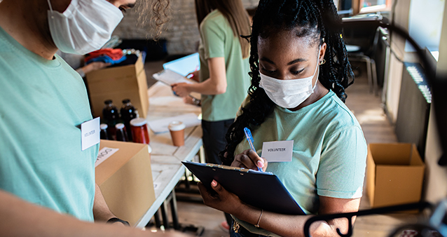 Teenage volunteers sorting clothing donations in community center