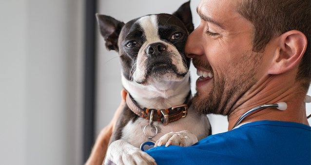 Smiling man holding a dog