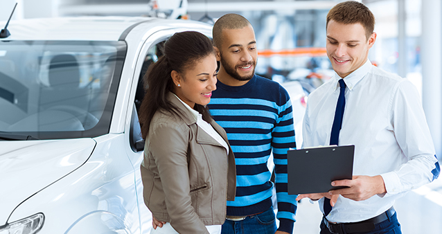 A couple consults with a salesman to use low interest rate to buy new car