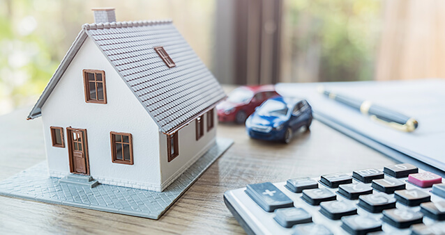 Model home and cars showcasing the different types of insurance for your home and car.