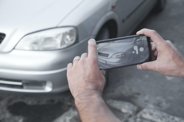 Man takes photograph of car for insurance purposes