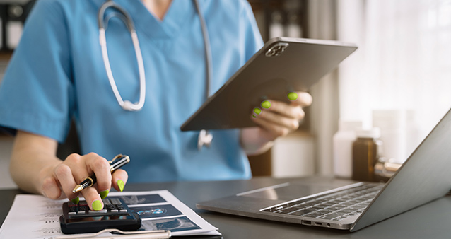 Nurse using a tablet and calculator