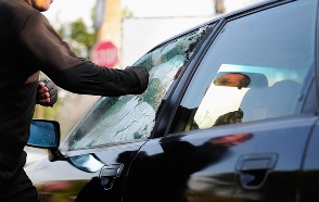 Man breaking a car window