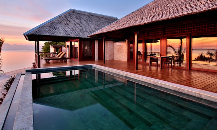 Beautiful ocean-view  house, with wooden patio leading to a swimming pool with view of the ocean in background