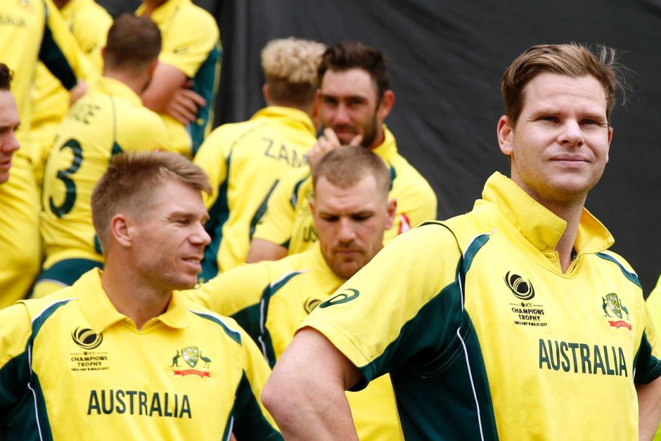 Australian cricket team members walking out lead by Aaron Finch and Steve Smith.
