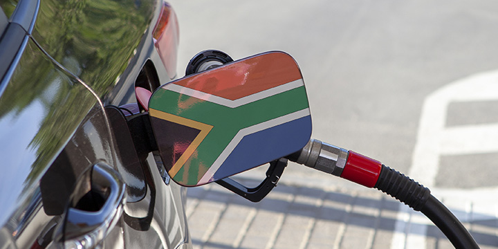 Car with South African flag on the open petrol cap as the car is being filled up with petrol