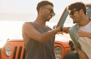 2 guys fist pump in front of car