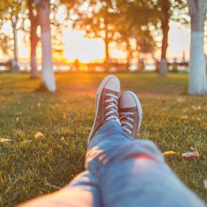 Guy relaxing legs stretched on grass