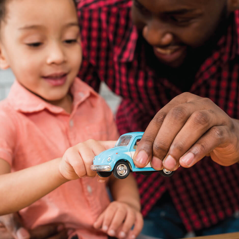 Father showing child vw beetle toy car