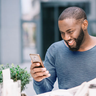 Man smiling down into cellphone 