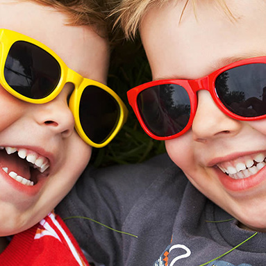 two kids laying on the grass smiling