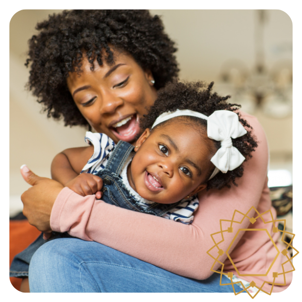 Mom holding daughter as they both smile